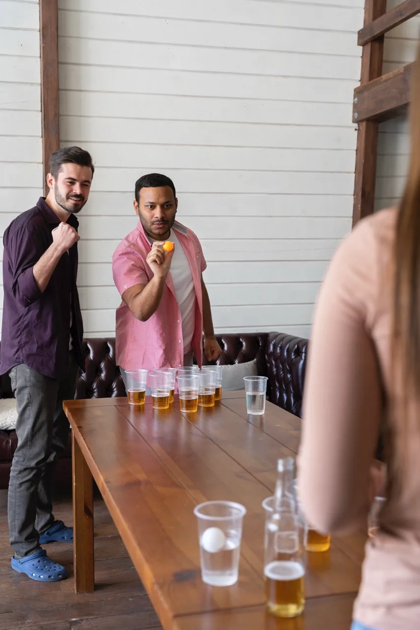 friends-enjoying-game-beer-pong-indoor-party Large